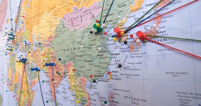 A map of the world, with pins representing the travels of the SIS community.